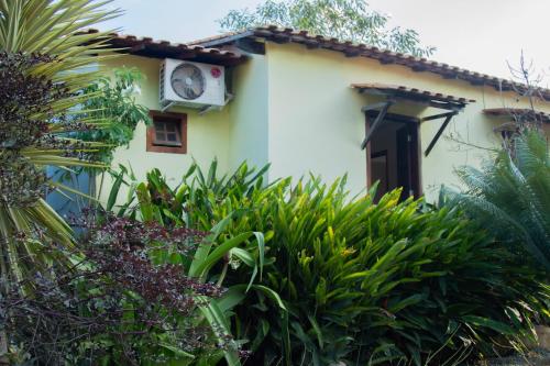 a white house with a clock on the side of it at Pousada Villa Bella in Palmeiras