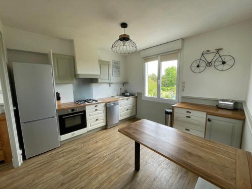 - une cuisine avec une table et un vélo sur le mur dans l'établissement Maison à 500m du port de Barfleur, à Gatteville-le-Phare