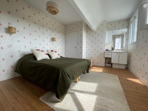 une chambre avec un lit avec une couette verte dans l'établissement Maison à 500m du port de Barfleur, à Gatteville-le-Phare