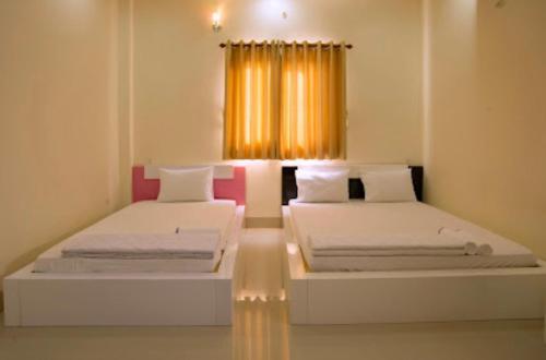 2 Betten in einem Zimmer mit Fenster in der Unterkunft Sao Mai An Giang Hotel in Ấp Mỹ Thạnh