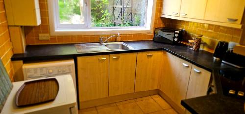 a small kitchen with a sink and a window at Home away from home in Aberdeen