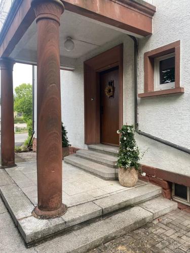 a front door of a house with a potted plant at Dachgeschosswohnung in Altbauvilla in Weilerbach