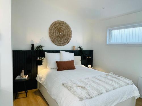 1 dormitorio con 1 cama blanca grande con sábanas blancas en Pavillon Neuf Baie de Tadoussac Clim Parking - 1 chambre en Tadoussac