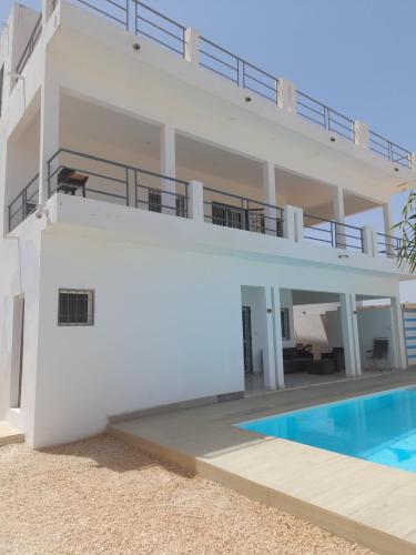 uma villa com uma piscina e uma casa em La doré du Sénégal em Somone