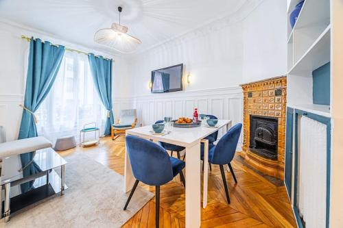 un salon avec une table et des chaises et une cheminée dans l'établissement Appartement Haussmannien proche Parc des Princes, à Paris