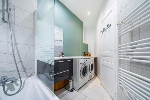une salle de bain avec une machine à laver et un lave-linge dans l'établissement Appartement Haussmannien proche Parc des Princes, à Paris