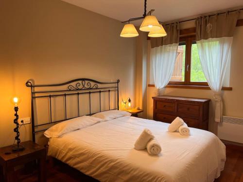 a bedroom with a large bed with towels on it at Cal Mestre - L'Amfitriona in Rialp