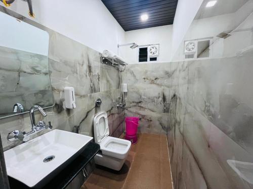 a bathroom with a sink and a toilet at Gulmarg Residency in Mount Ābu
