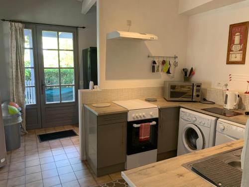 een keuken met een wasmachine en een wasmachine bij Maison des Roses in Saint-Savinien