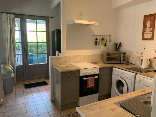 a kitchen with a washing machine and a washer at Maison des Roses in Saint-Savinien