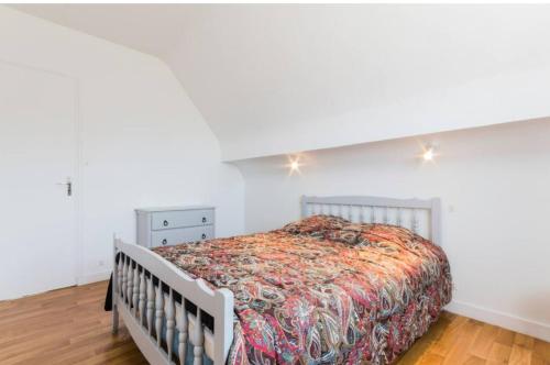 a bedroom with a bed and a white wall at Maison familiale pour 8 - 850m de la plage in Le Pouliguen