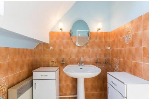 a bathroom with a sink and a mirror at Maison familiale pour 8 - 850m de la plage in Le Pouliguen