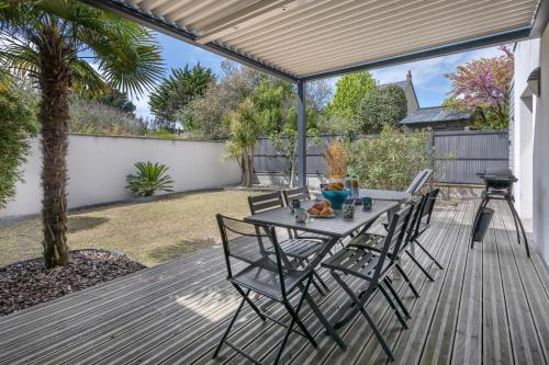 un patio avec une table et des chaises sur une terrasse dans l'établissement Maison 3 chambres avec beau jardin à Guérande, à Guérande