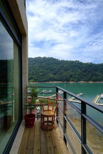 a balcony with two chairs and a view of a river at Lakeview Homestay in Yuchi