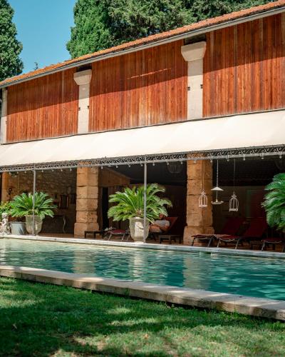 a building with a swimming pool in front of it at Mas des Comtes de Provence in Tarascon