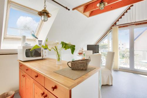 une cuisine avec un comptoir avec un micro-ondes dessus dans l'établissement Sous les toits tout près de la mer à Erquy, à Erquy