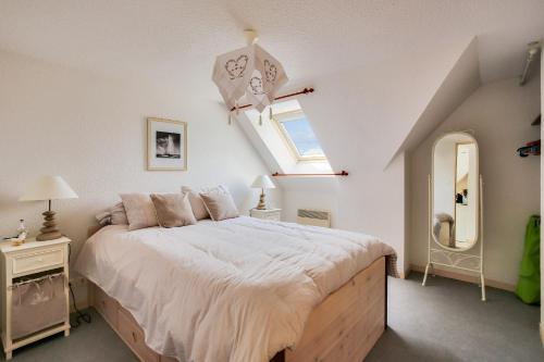 une chambre avec un grand lit et une fenêtre dans l'établissement Sous les toits tout près de la mer à Erquy, à Erquy