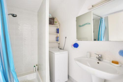 une salle de bain blanche avec un lavabo et des toilettes dans l'établissement Sous les toits tout près de la mer à Erquy, à Erquy