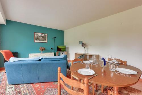 un salon avec une table et un canapé bleu dans l'établissement Arradon - Terrasse et Plancha !, à Arradon