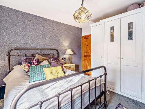 sypialnia z metalowym łóżkiem i kolorowymi poduszkami w obiekcie 1 Bed in Ulverston 82447 w mieście Gleaston