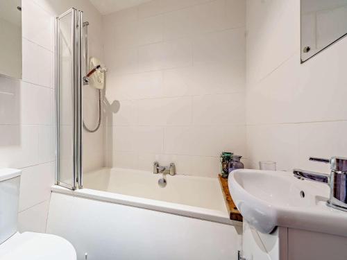 La salle de bains blanche est pourvue d'une baignoire et d'un lavabo. dans l'établissement 1 Bed in Ulverston 82447, à Gleaston