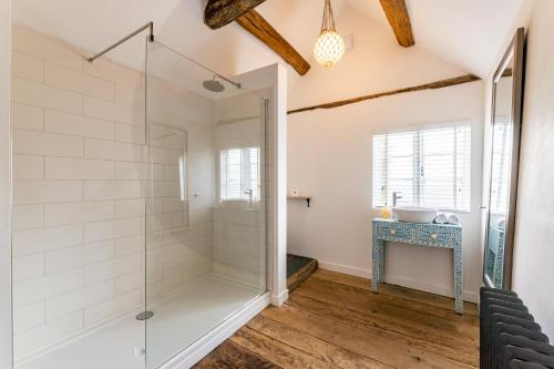 baño con cabina de ducha de cristal y lavamanos en The Art Studio en Henley in Arden