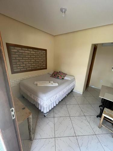 a bedroom with a bed in a room with a brick wall at Pousada Villa Bella in Palmeiras