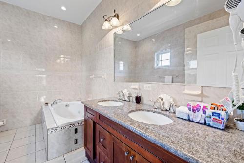 ein Badezimmer mit zwei Waschbecken und einem großen Spiegel in der Unterkunft The Miller House in Nassau