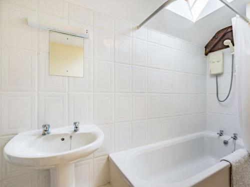 a white bathroom with a sink and a bath tub at 3 Bed in Blanchland CN110 