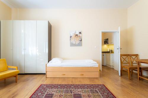 een slaapkamer met een bed en een eetkamer bij Victus Apartamenty, Apartament Garden in Sopot