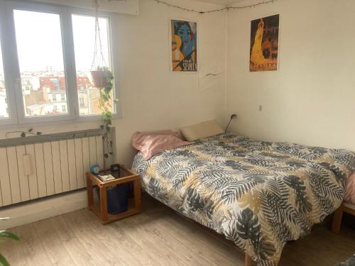 une petite chambre avec un lit et une table dans l'établissement Nice 2 bedrooms flat in the center of Paris with terrasse and incredible view, à Paris