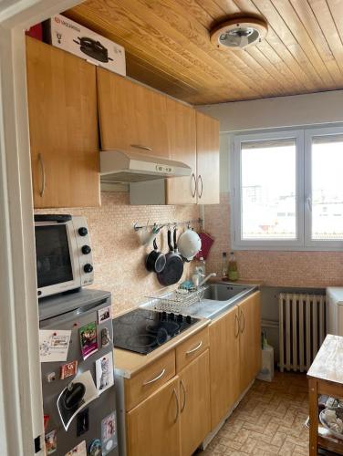 une cuisine avec un évier et une cuisinière four supérieur dans l'établissement Nice 2 bedrooms flat in the center of Paris with terrasse and incredible view, à Paris