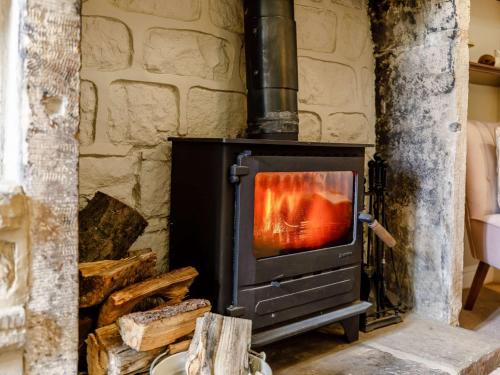 a wood stove in a room with a stone wall at 2 Bed in Harrogate 75268 in Lindley