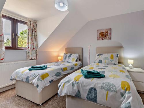 a bedroom with two beds and a window at 4 Bed in Wareham 77511 in Stoborough