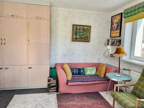 a living room with a pink couch and a table at LITTLE LONDON boutique apartment with Netflix, top location in Old Town in Narva