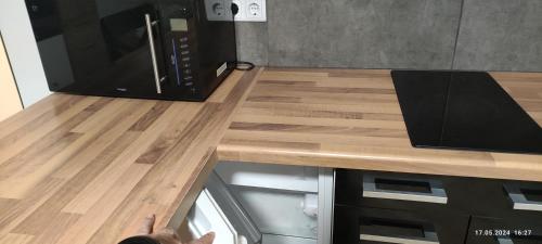 a kitchen with a wooden counter top with a microwave at A6 Apartment in Kirchardt