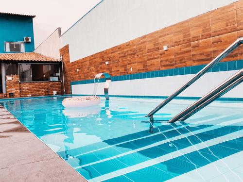 バヘイリーニャスにあるPousada Vila Lençóis Sport & Pousadaの青い水と階段が備わるスイミングプール