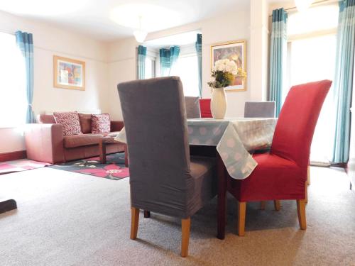 ein Wohnzimmer mit einem Klavier und roten Stühlen in der Unterkunft Stay Norwich Apartments Trade Stay House in Norwich