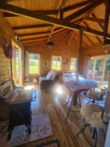 uma grande sala de estar com um sofá e uma mesa em Cabana Leão Baio em Urubici