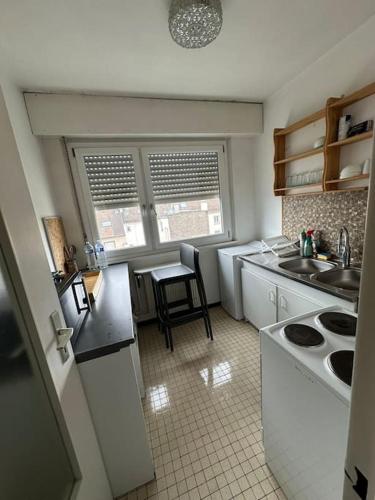 une cuisine avec un évier et une table à l'intérieur dans l'établissement Cozy Apartment in Central Strasbourg, à Strasbourg