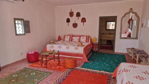 Schlafzimmer mit einem Bett und einem Spiegel in der Unterkunft Les Trois Paons in Taroudant