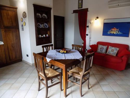 una sala da pranzo con tavolo e divano rosso di Archi di San Giacomo a Cammarata