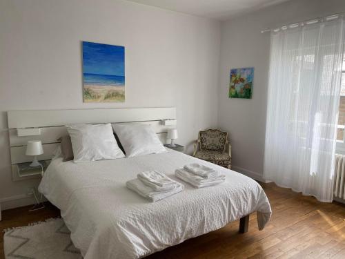 a bedroom with a white bed with towels on it at AQUARELLE in Avranches
