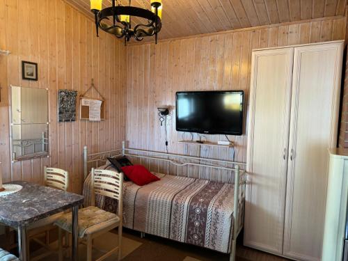a bedroom with a bed and a tv on the wall at Verlan Satumaa in Verla
