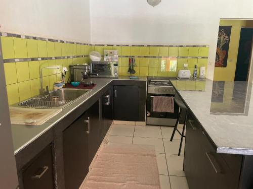a small kitchen with a sink and a stove at Sergio chambre d hôte in Sali Nianiaral