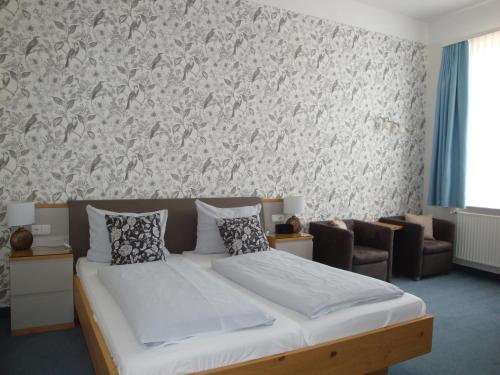 a bedroom with a bed and a wall at Hotel Bellevue in Hameln