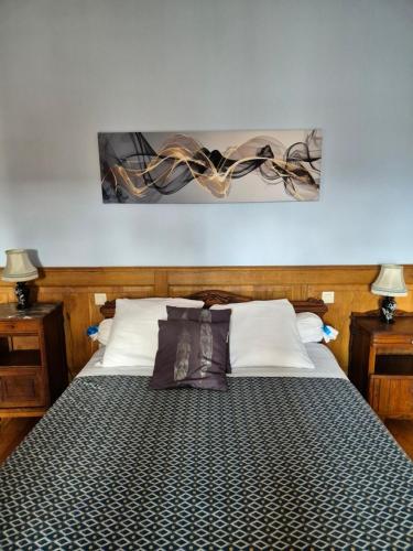 un letto in una camera con due comodini e due lampade di La Bagatelle a Pontorson