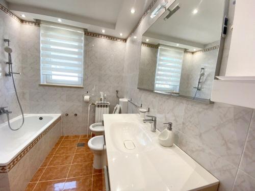 y baño con lavabo, aseo y bañera. en One bedroom apartement at Novigrad 400 m away from the beach with enclosed garden and wifi, en Novigrad Istria