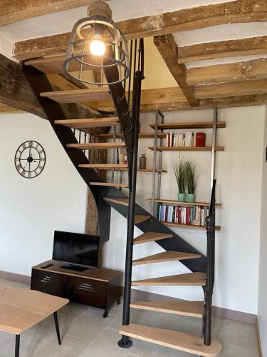 a spiral staircase in a loft conversion with a desk at Maison bord de Loire in Saint-Clément-des-Levées