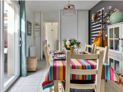 une salle à manger avec une table et un tissu de table coloré dans l'établissement Maison Les Agapanthes, à Les Sables-dʼOlonne